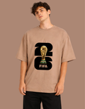 Person wearing a brown t-shirt with FIFA World Cup trophy graphic on a beige background
