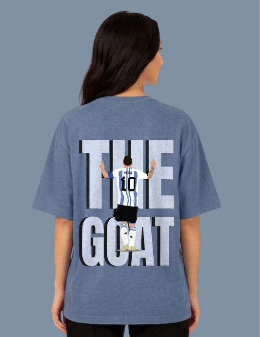 Person wearing a blue t-shirt with 'THE GOAT' graphic on the back