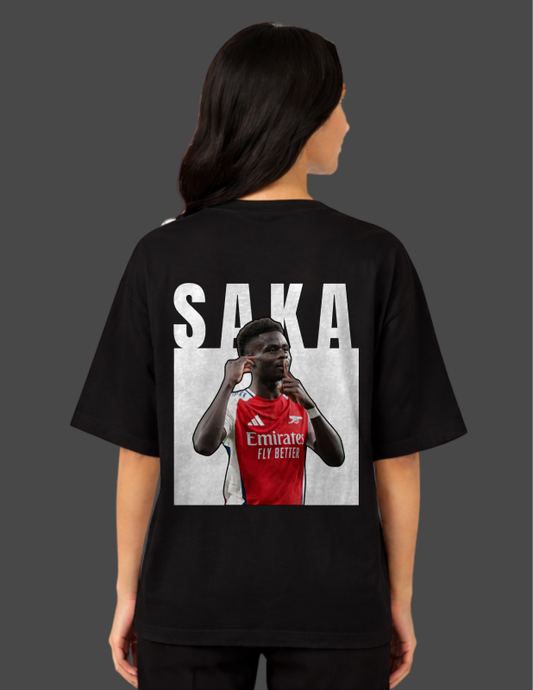 Person wearing a black t-shirt with a graphic of a football player and the name 'Saka' on the back.