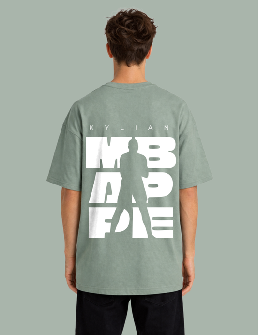 Person wearing a green t-shirt with white text on the back against a gray background