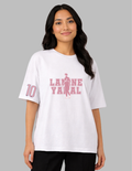 Woman wearing a white t-shirt with pink text and graphics on a gray background