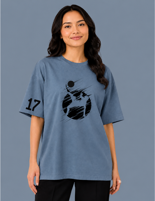 Person wearing a blue t-shirt with a graphic design on a gray background