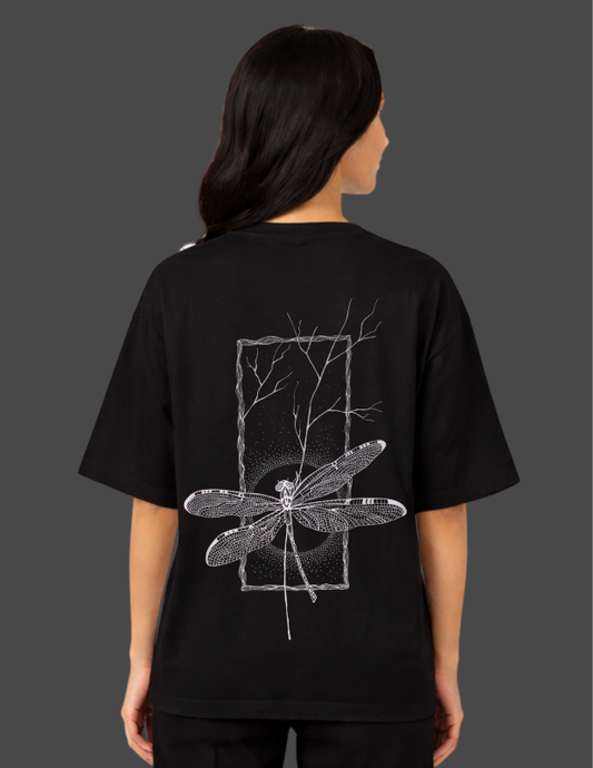Person wearing a black t-shirt with a white dragonfly design on the back against a dark background