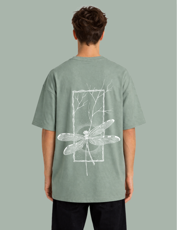 Person wearing a green t-shirt with a white dragonfly design on the back against a gray background