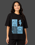 Person wearing a black t-shirt with blue graphic design on a dark background