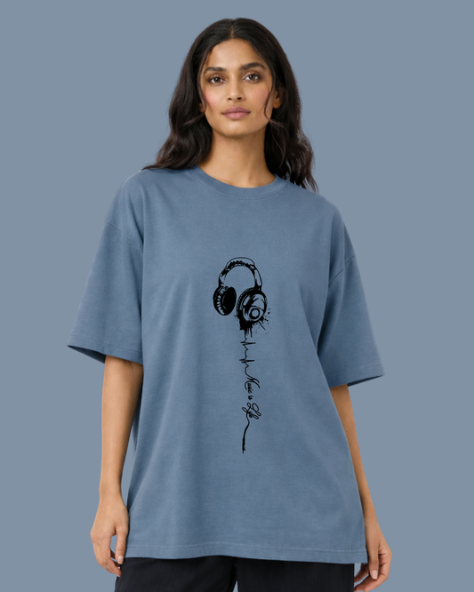 Woman wearing a blue t-shirt with a black headphone design on a gray background