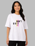 Woman wearing a white t-shirt with 'DON'T QUIT NOW' text on a gray background