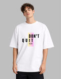 Person wearing a white t-shirt with 'DON'T QUIT NOW' text on a gray background