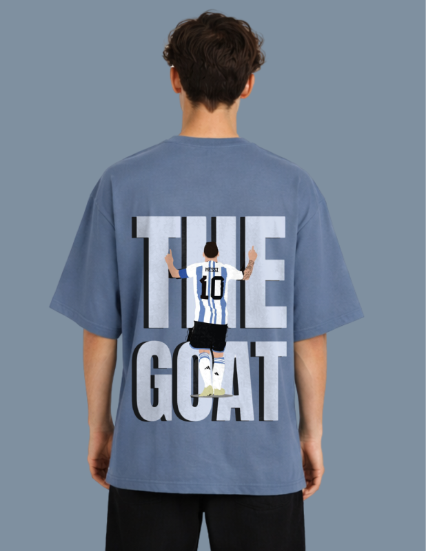 Person wearing a blue t-shirt with 'The Goat' graphic on the back against a gray background