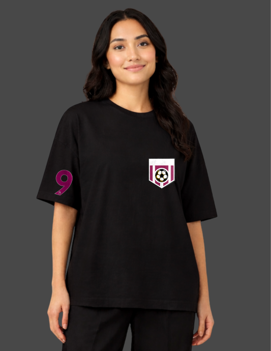 Person wearing a black t-shirt with a colorful graphic on a dark background