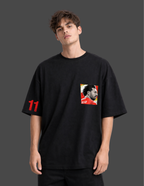 Person wearing a black t-shirt with a graphic design on a dark background