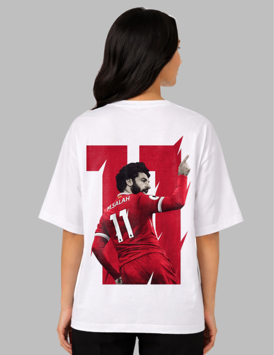 Person wearing a white t-shirt with a graphic of a soccer player in red on the back.