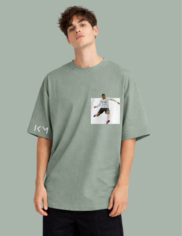 Person wearing a green t-shirt with a graphic design on a gray background
