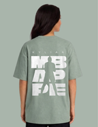 Person wearing a green t-shirt with white text and silhouette on a gray background