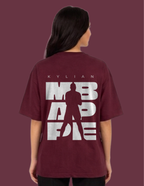 Person wearing a maroon t-shirt with white text and silhouette on a dark red background