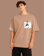 Man wearing a brown t-shirt with a graphic design on a brown background