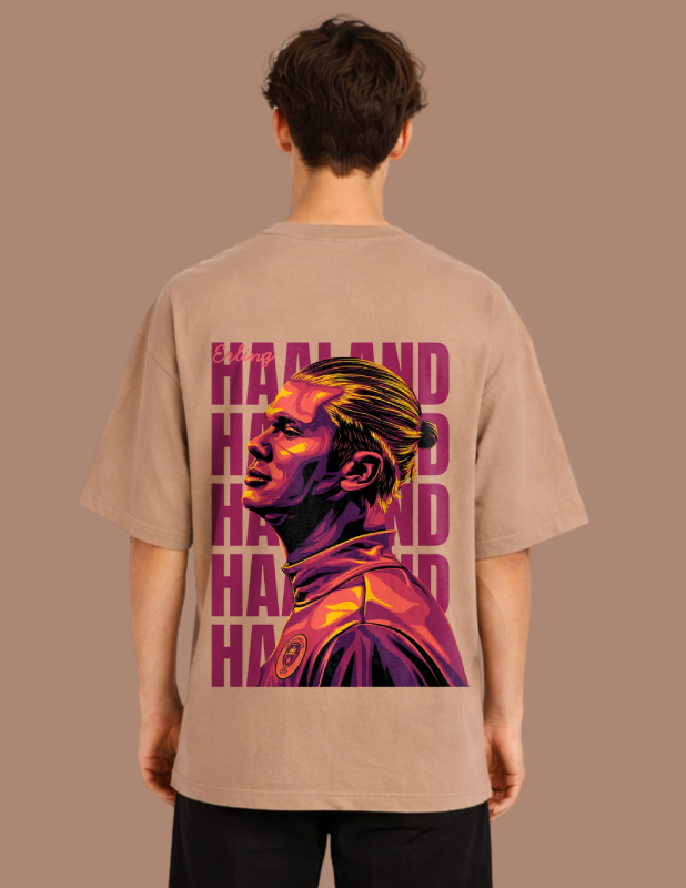 Person wearing a beige t-shirt with a colorful graphic and text on the back against a brown background