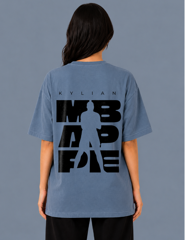 Person wearing a blue t-shirt with a graphic design on the back against a gray background