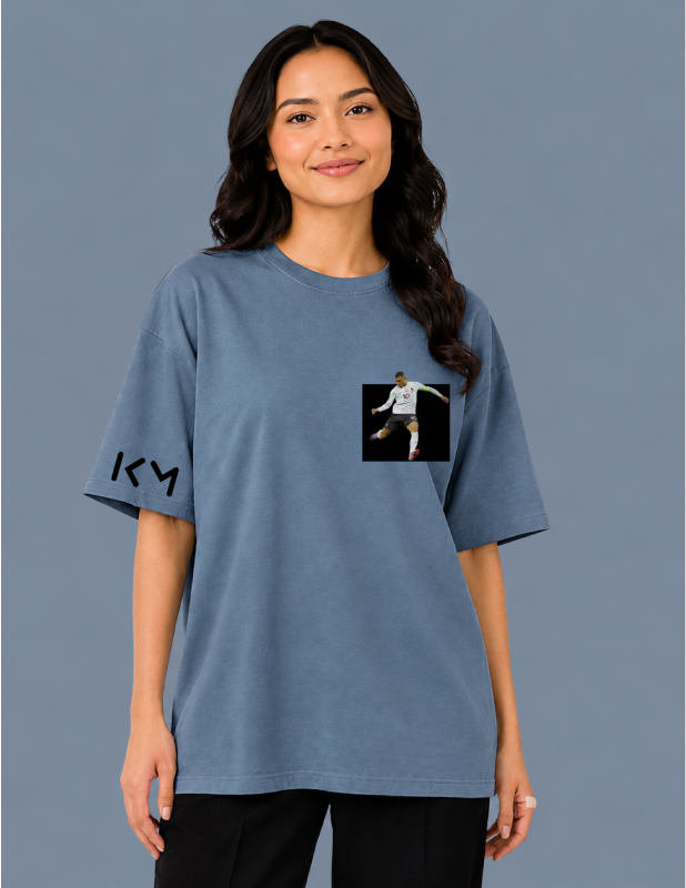 Person wearing a blue t-shirt with a logo on a gray background