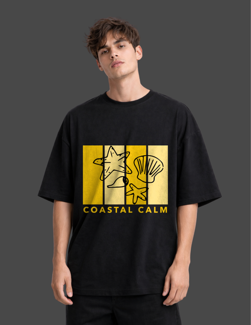 Person wearing a black t-shirt with a yellow graphic and 'Coastal Calm' text on a dark background