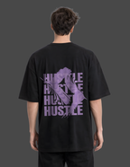 Person wearing a black t-shirt with purple graphic and text on the back