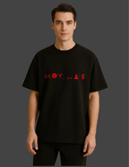 Person wearing a black t-shirt with red symbols on a dark background