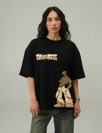 Person wearing a black t-shirt with graphic design and text on a plain background