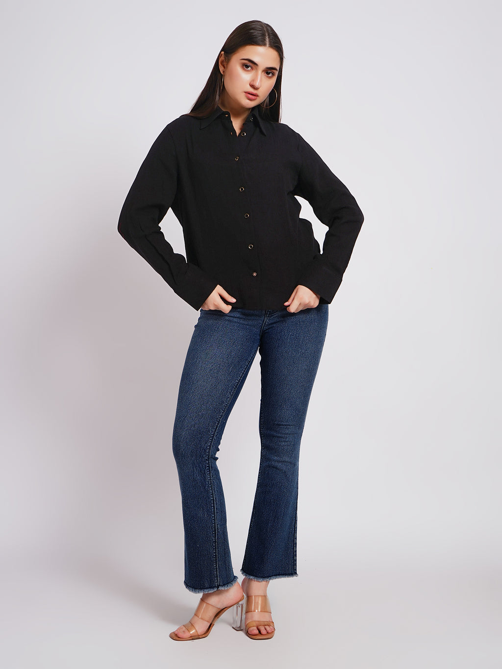 Woman wearing a black shirt and blue jeans on a white background
