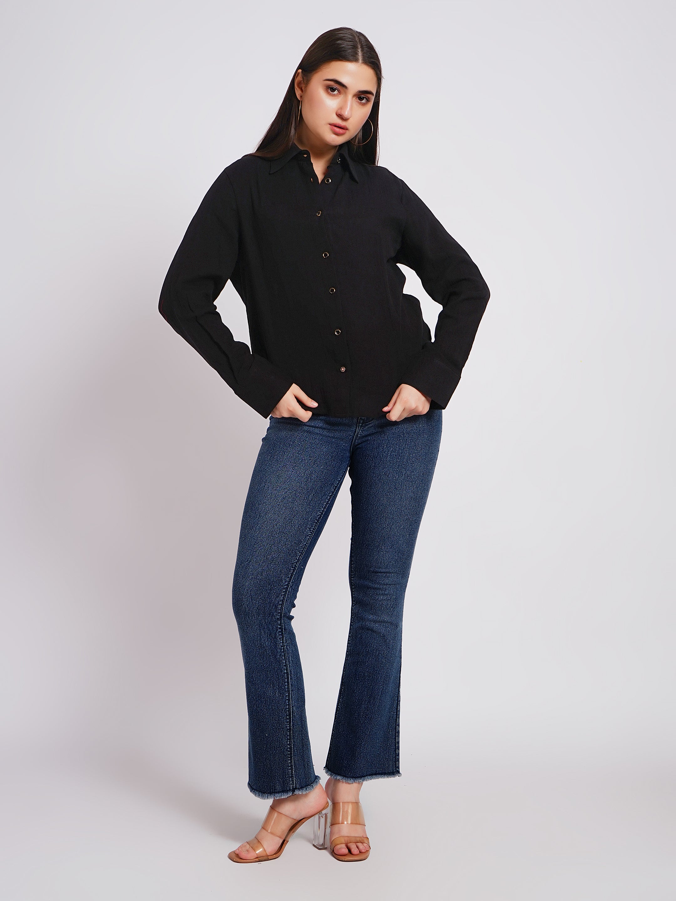 Woman wearing a black shirt and blue jeans on a white background