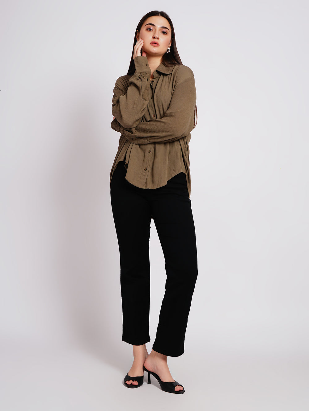 Woman wearing a green shirt and black pants on a white background