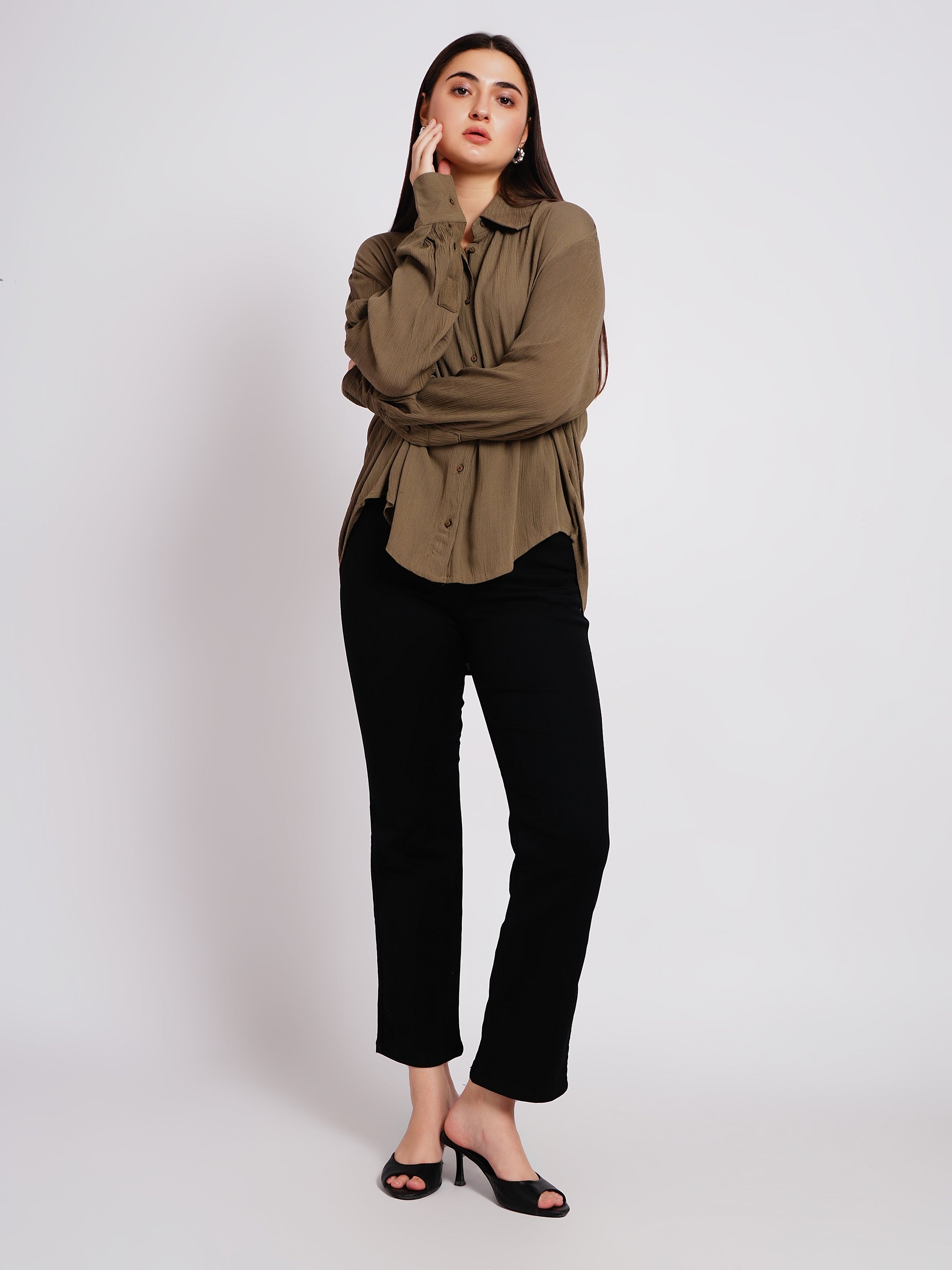 Woman wearing a green shirt and black pants on a white background
