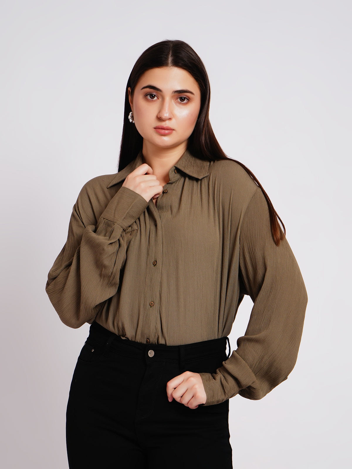 Woman wearing a brown blouse against a plain background
