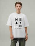 Person wearing a white t-shirt with 'HEAVEN IS THE GOAL' text on a plain background